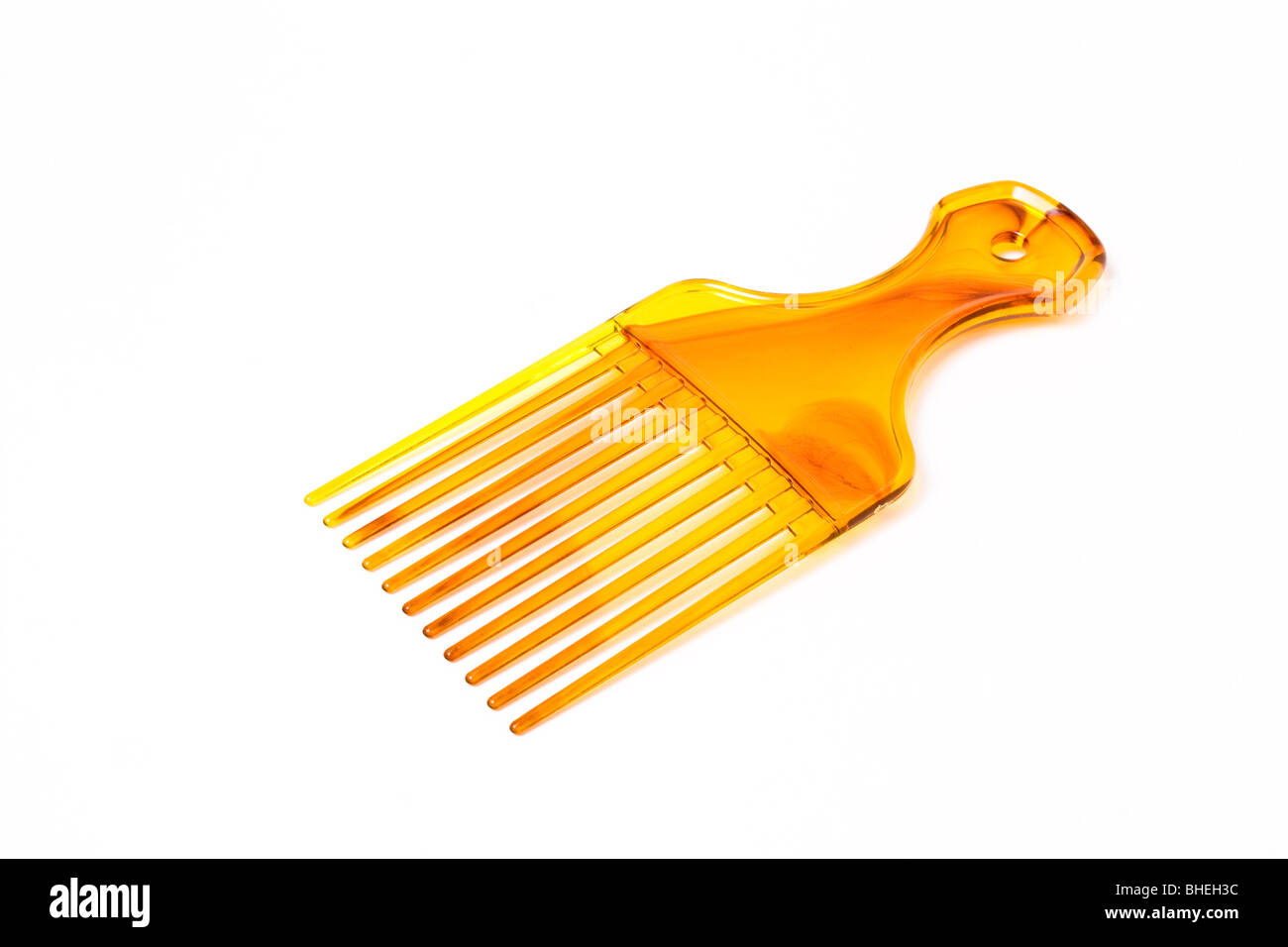 Wide plastic afro comb from low viewpoint isolated against white background. Stock Photo