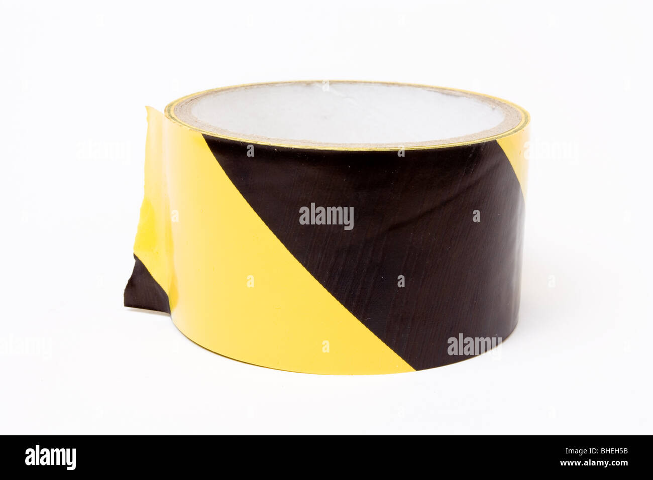 Roll of yellow and black high visibility tape isolated against white background. Stock Photo