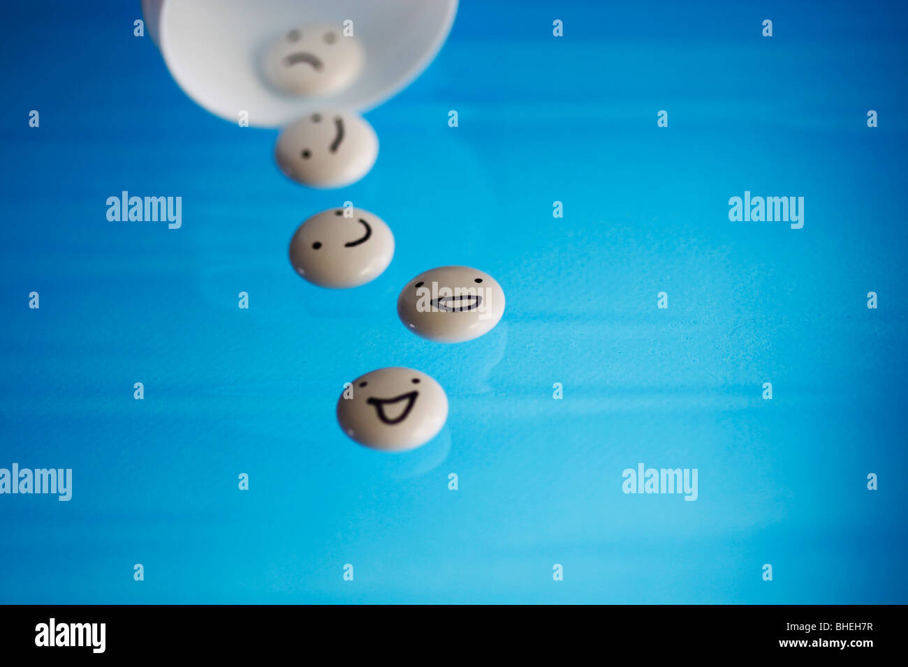 White tablets with mood faces on blue background Stock Photo