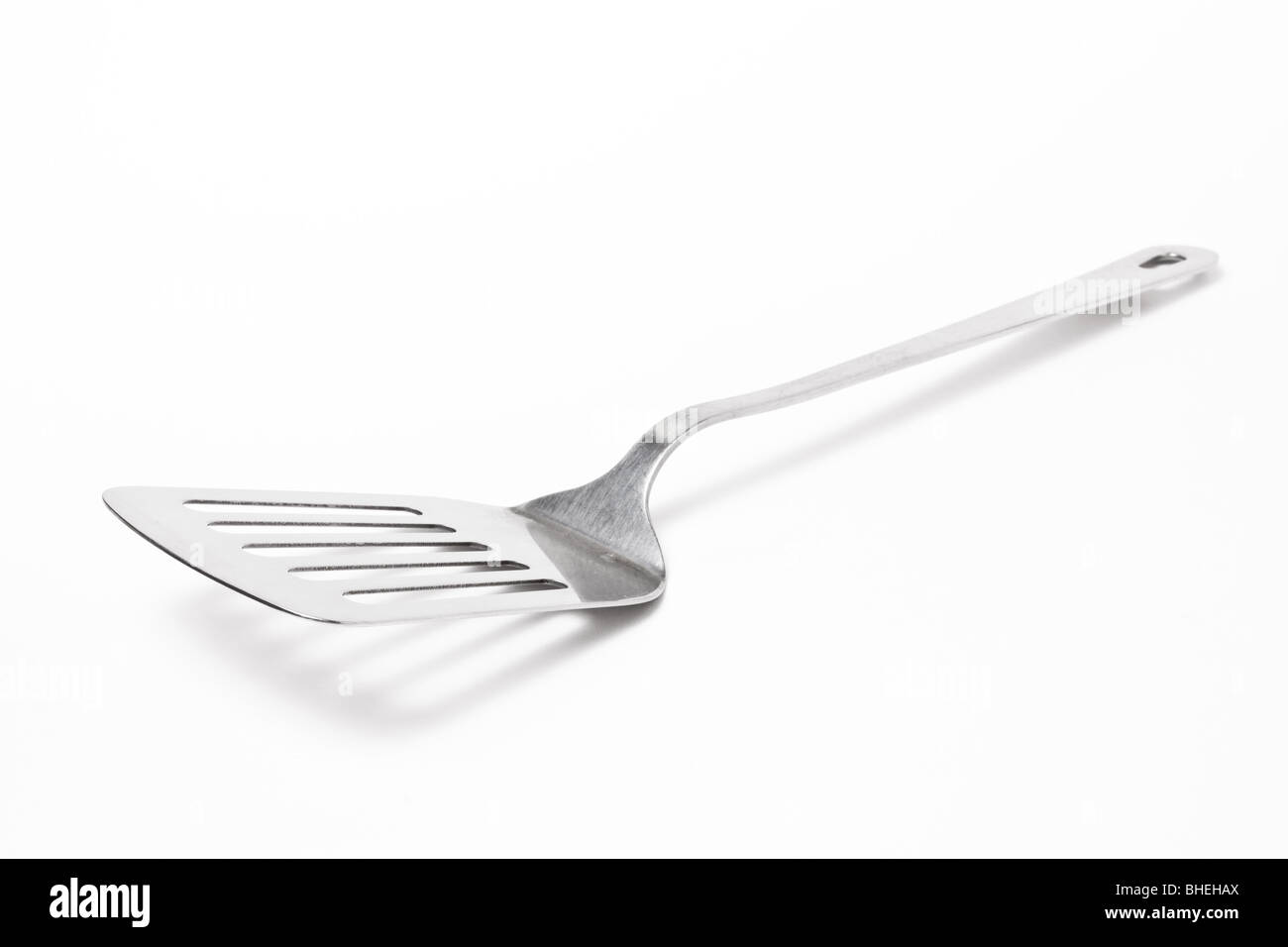 Large Stainless steel Kitchen spatula isolated against white background. Stock Photo