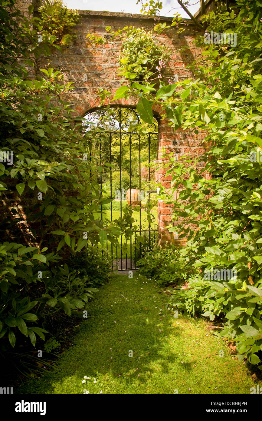 Wrought iron gate in a wall leading to a secret garden Stock Photo Alamy