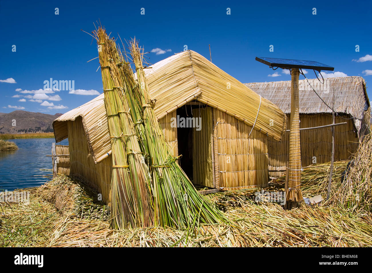 Huts made from totora reeds and a solar panel, blending old and modern technology. Uros Islands, Lake Titicaca,Peru Stock Photo