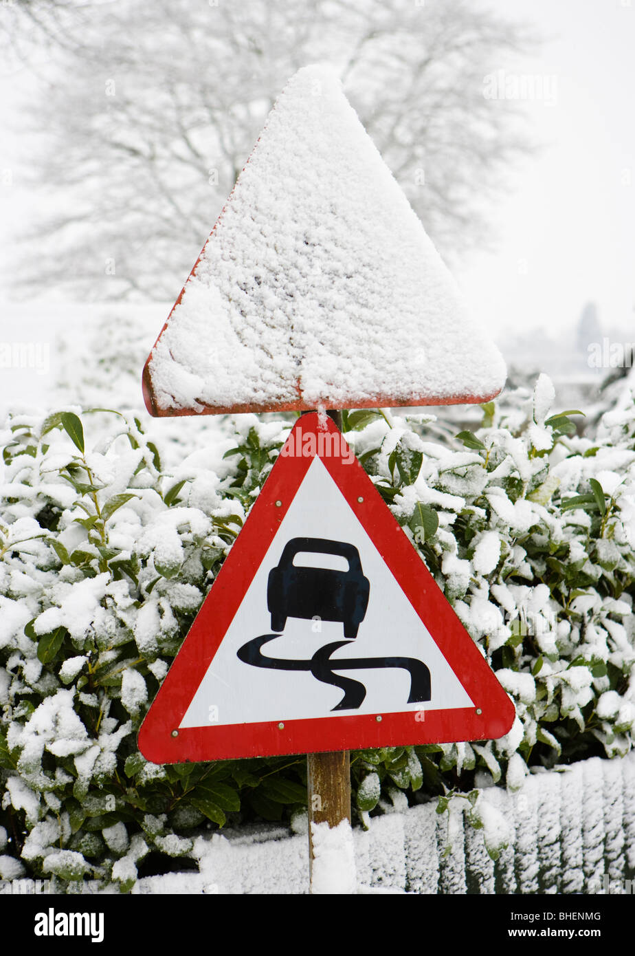 Danger, slippery road sign in winter. Stock Photo