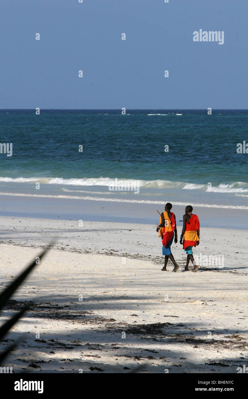 Kenyan Masai walking the beach by the Indian Ocean at Diani, Kenya Stock Photo