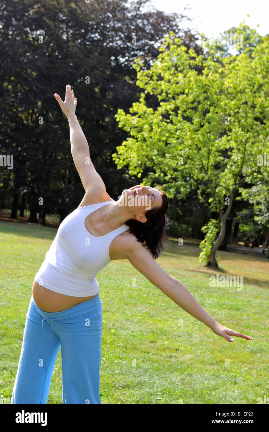 pregnant woman makes gymnastics outside, Schwangere Frau macht Gymnastik im Freien Stock Photo