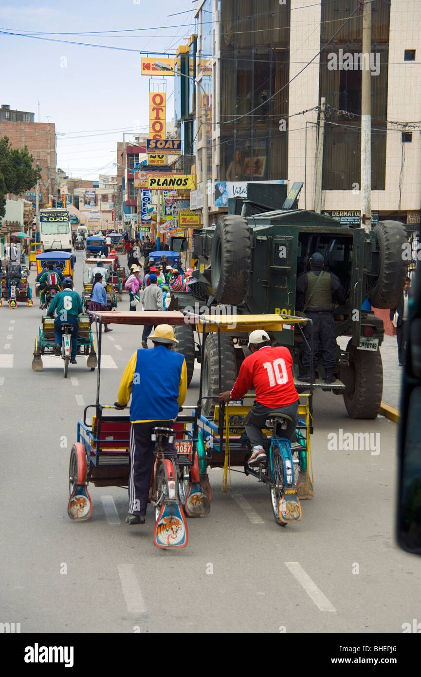 Rickshaws or trishaws and Police vehicle in the town of Juliaca Peru Stock Photo