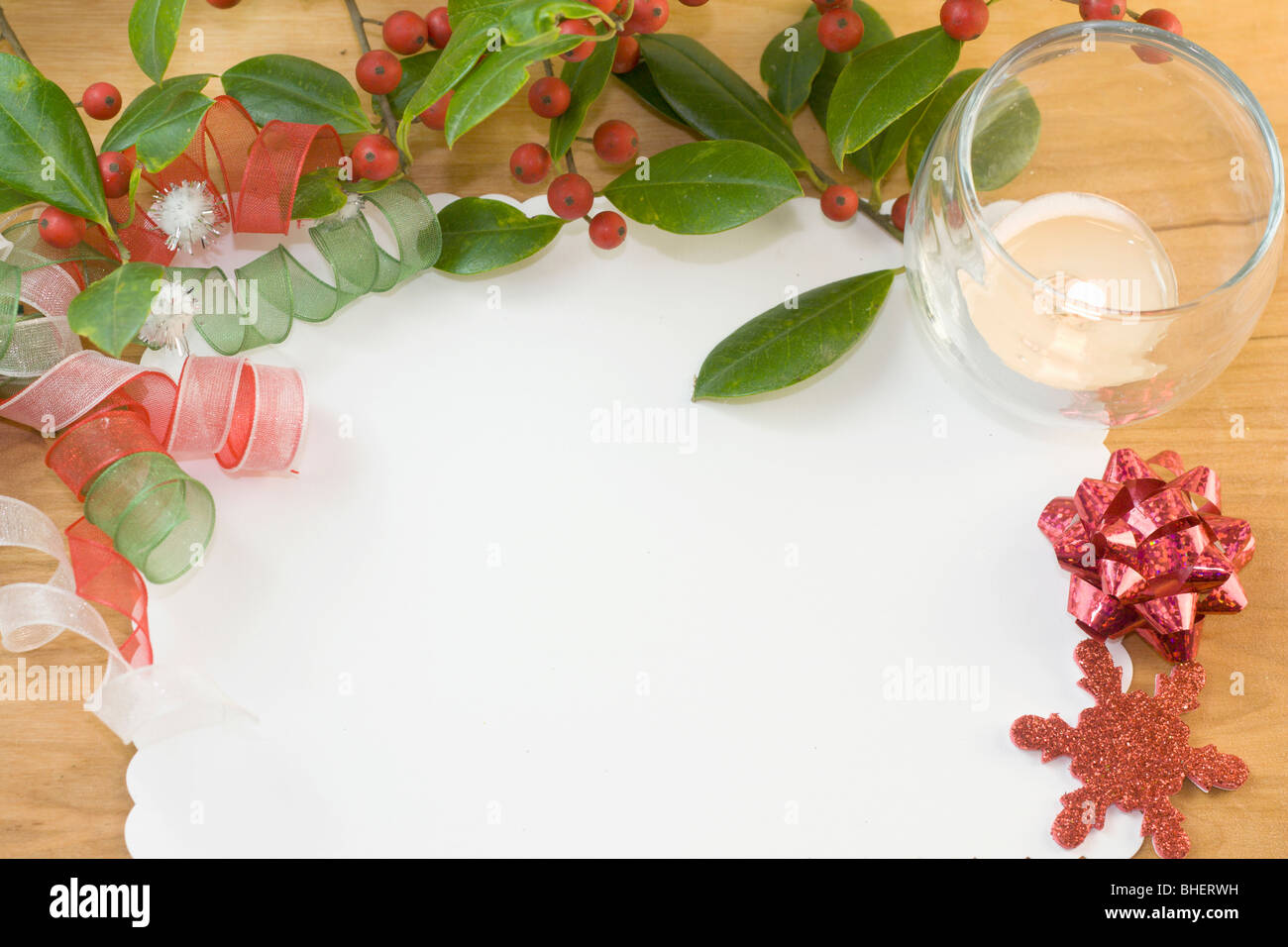 blank Christmas card with holly branch, tea light candle, and copyspace Stock Photo
