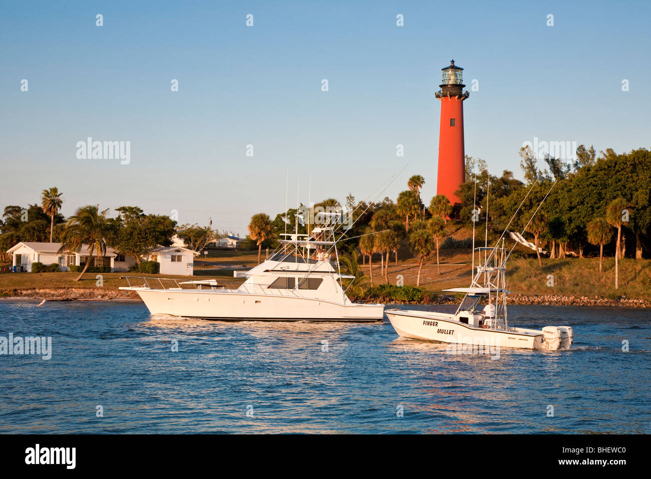 Private yacht and pleasure boat pass Jupiter Inlet Light lighthouse in