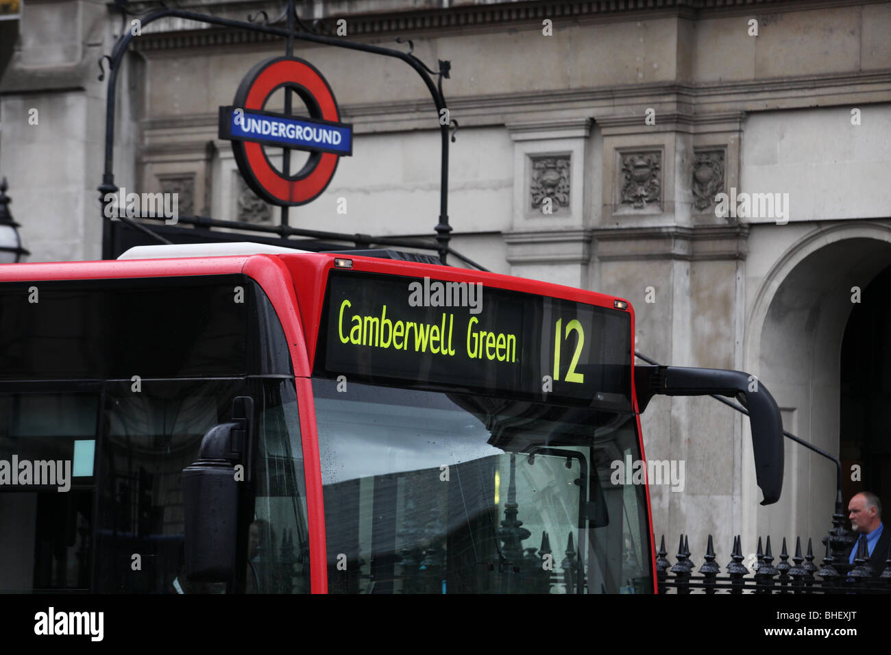 Red London Bendy Bus with Underground logo in background Stock Photo