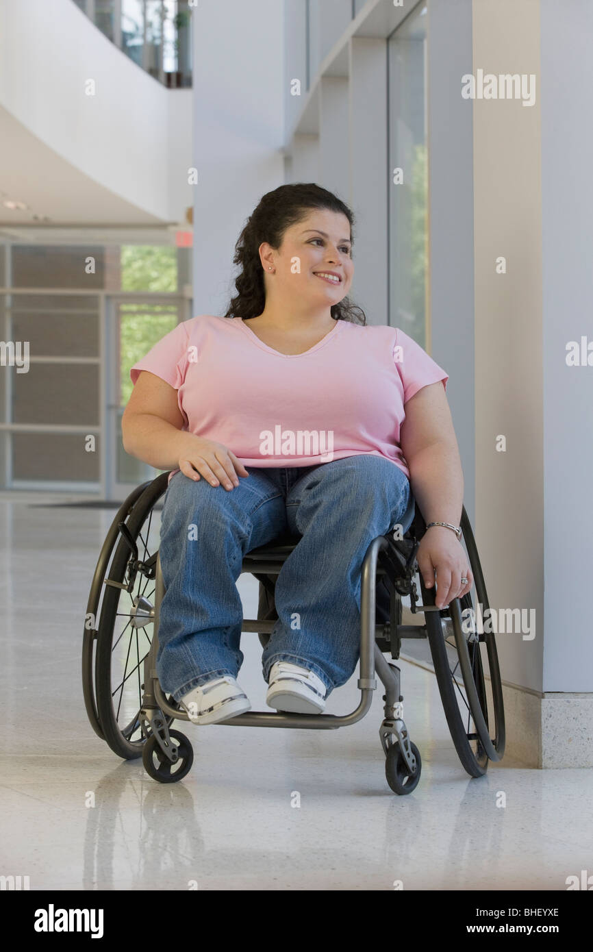Disabled woman sitting in a wheelchair and smiling Stock Photo - Alamy