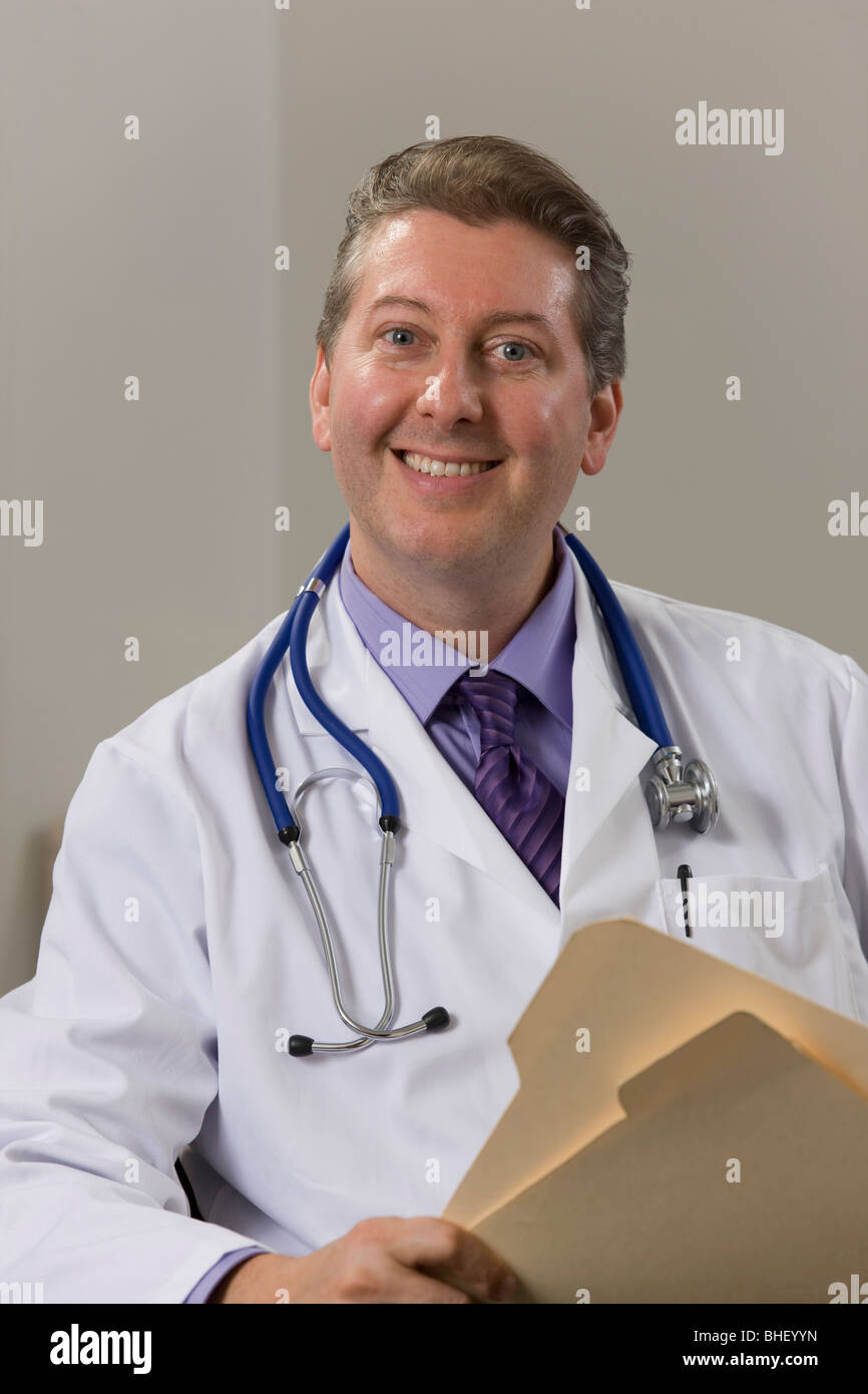 Smiling mature doctor sitting hi-res stock photography and images - Alamy