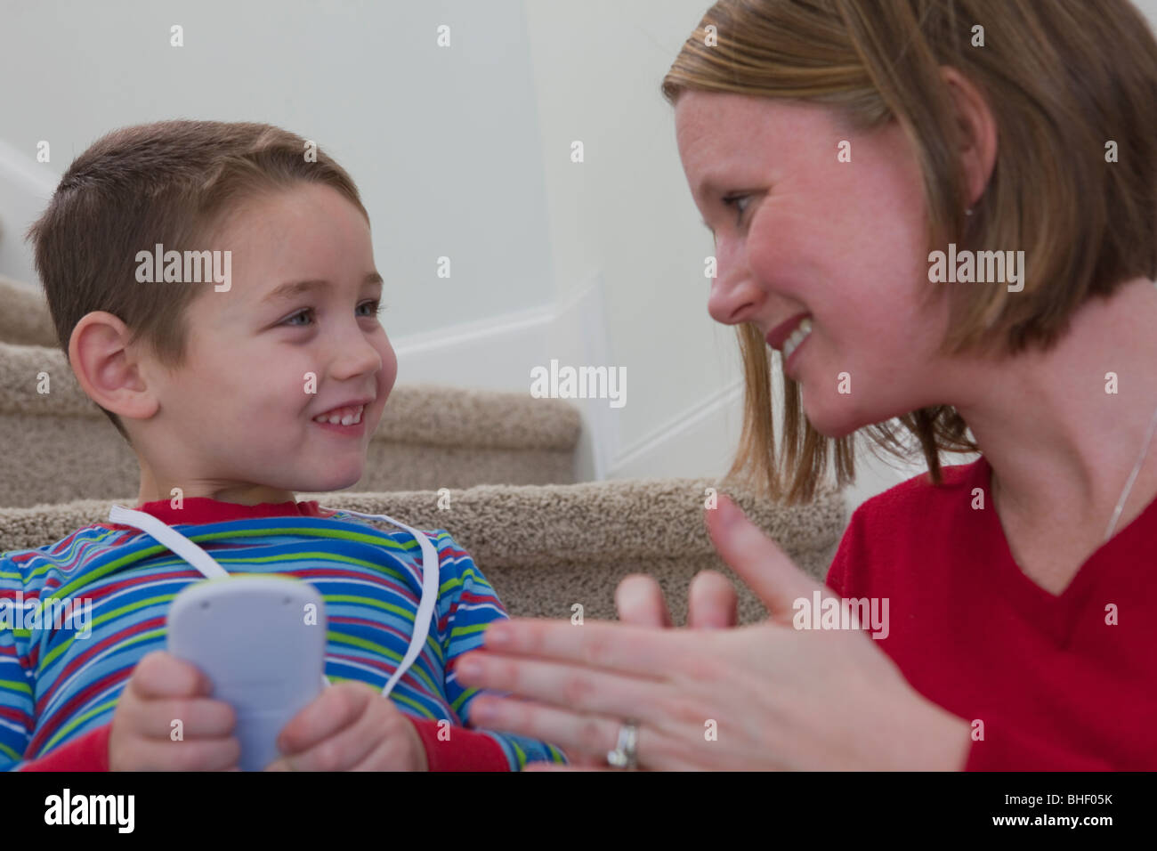 Woman signing the word 'Calculator' in American Sign Language while communicating with her son Stock Photo