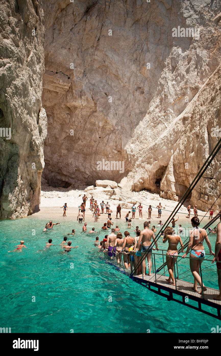 People descend from the ship into the water to swim in the crystal clear water in Zakynthos Stock Photo