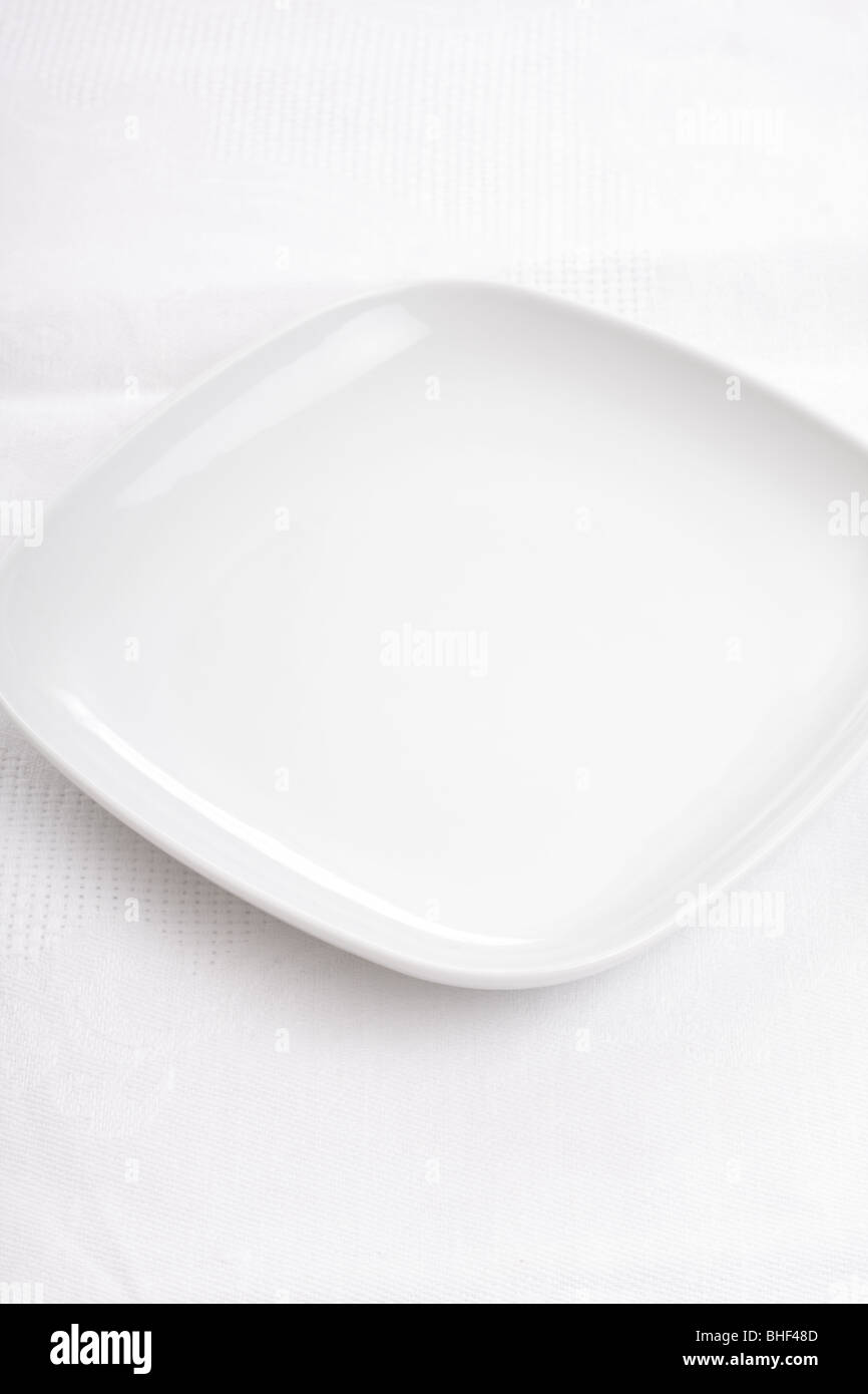 Empty white plate on a white napkin. Fill it! Make a photo collage! Stock Photo