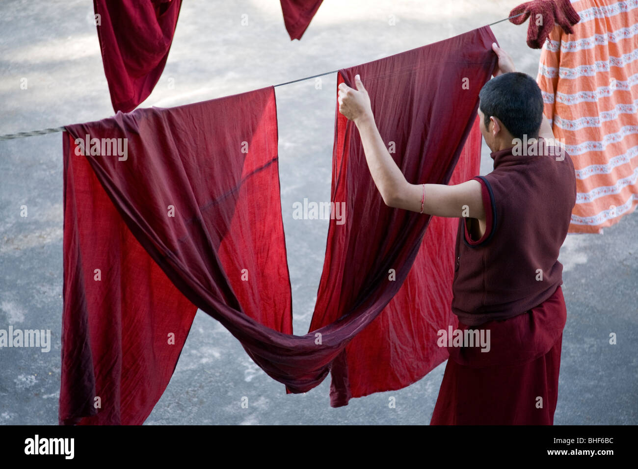 Buddhist monk putting a robe on the clothes line. McLeod Ganj