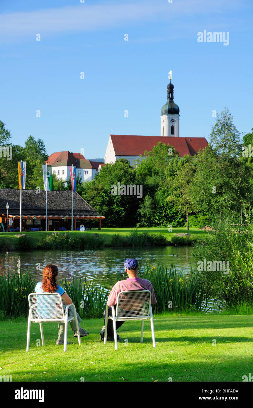 Couple sitting near pond in spa gardens, Bad Koetzting, Bavarian Forest, Upper Palatinate, Bavaria, Germany Stock Photo