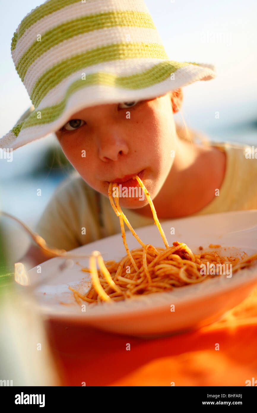Girl eating spaghetti, Formentera, Balearic Islands, Spain Stock Photo