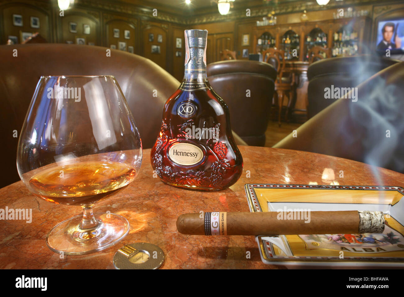 A glass of whiskey and a smoking cigar at the cigar lounge at Peacock Garden resort, Baclayon, Bohol, Philippines, Asia Stock Photo