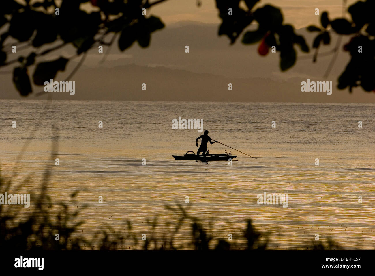 Man throwing spear from a canoo at sunset, New Britain, Papua New Guinea, Oceania Stock Photo