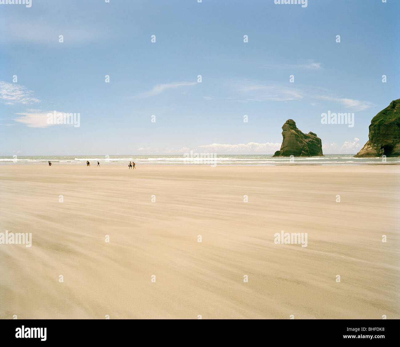 Sandy beach at lowtide in front of rock islands, Wharariki Beach, northwest coast, South Island, New Zealand Stock Photo