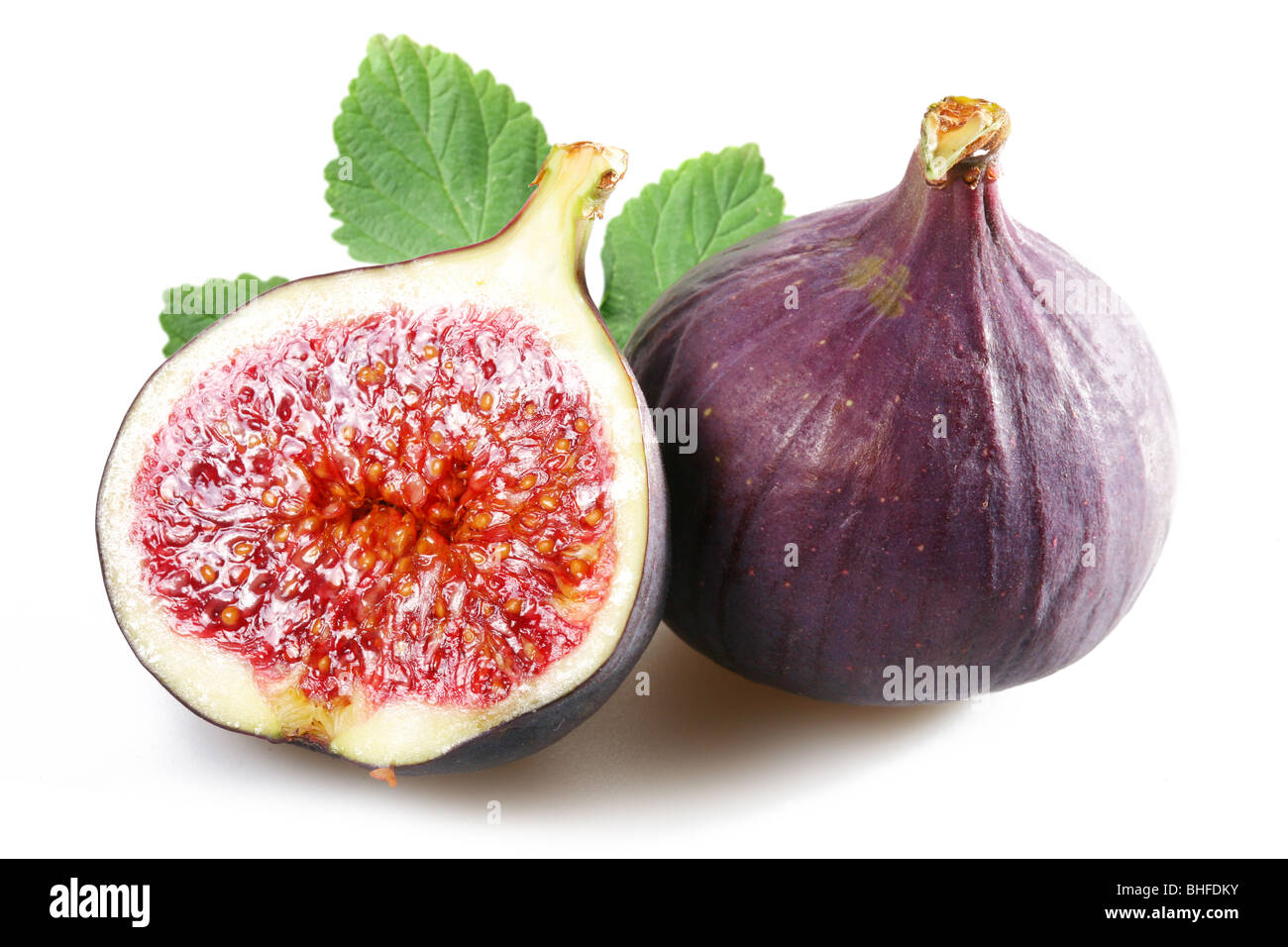 Figs with cut fruit and leaves on a white background Stock Photo