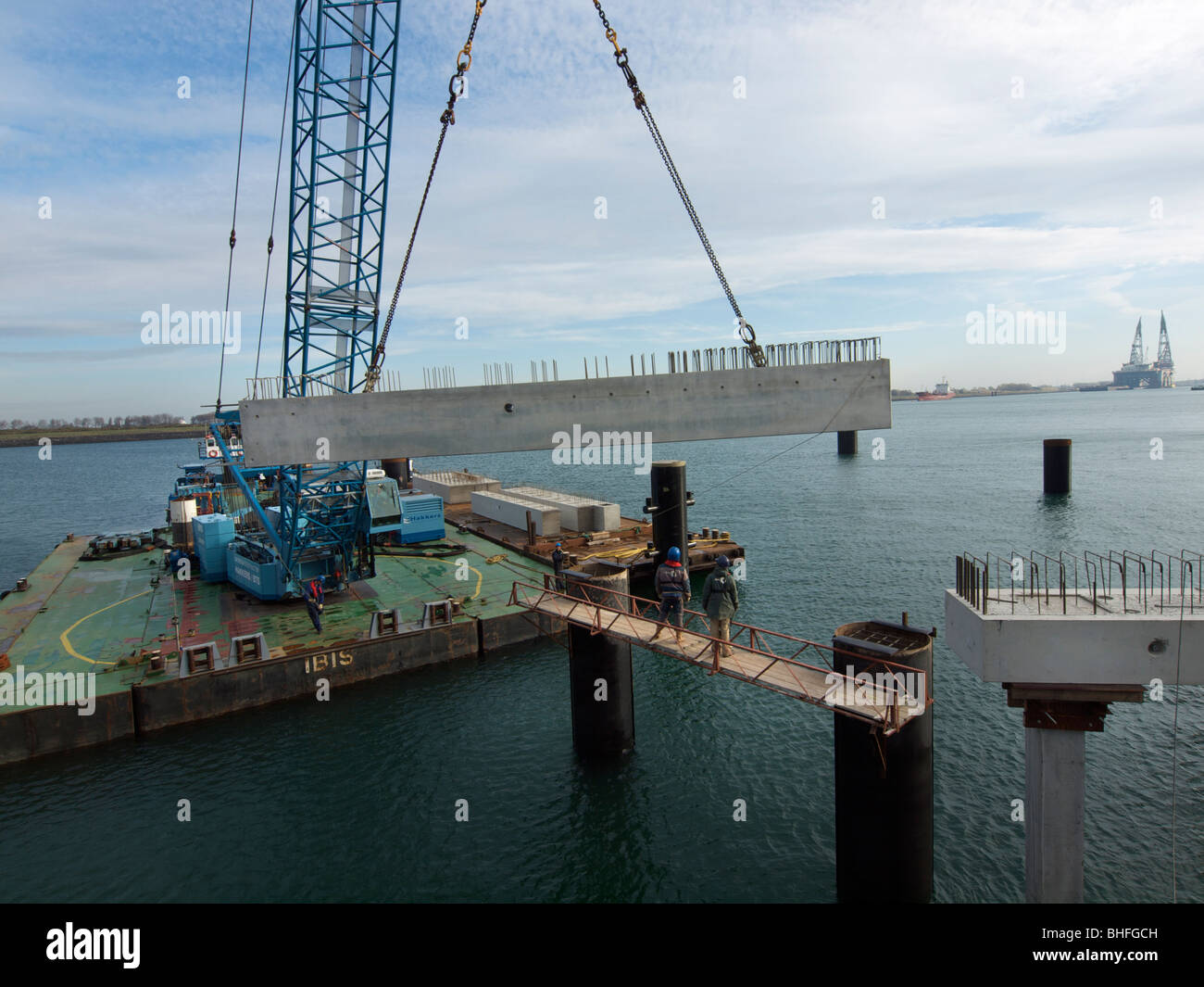 Large floating crane lifting a concrete beam into place while building