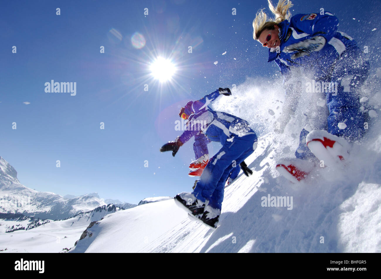 Two ski instructors jumping into fresh, powder snow, Mountain landscape in Winter, Seiser Alp, South Tyrol, Italy Stock Photo