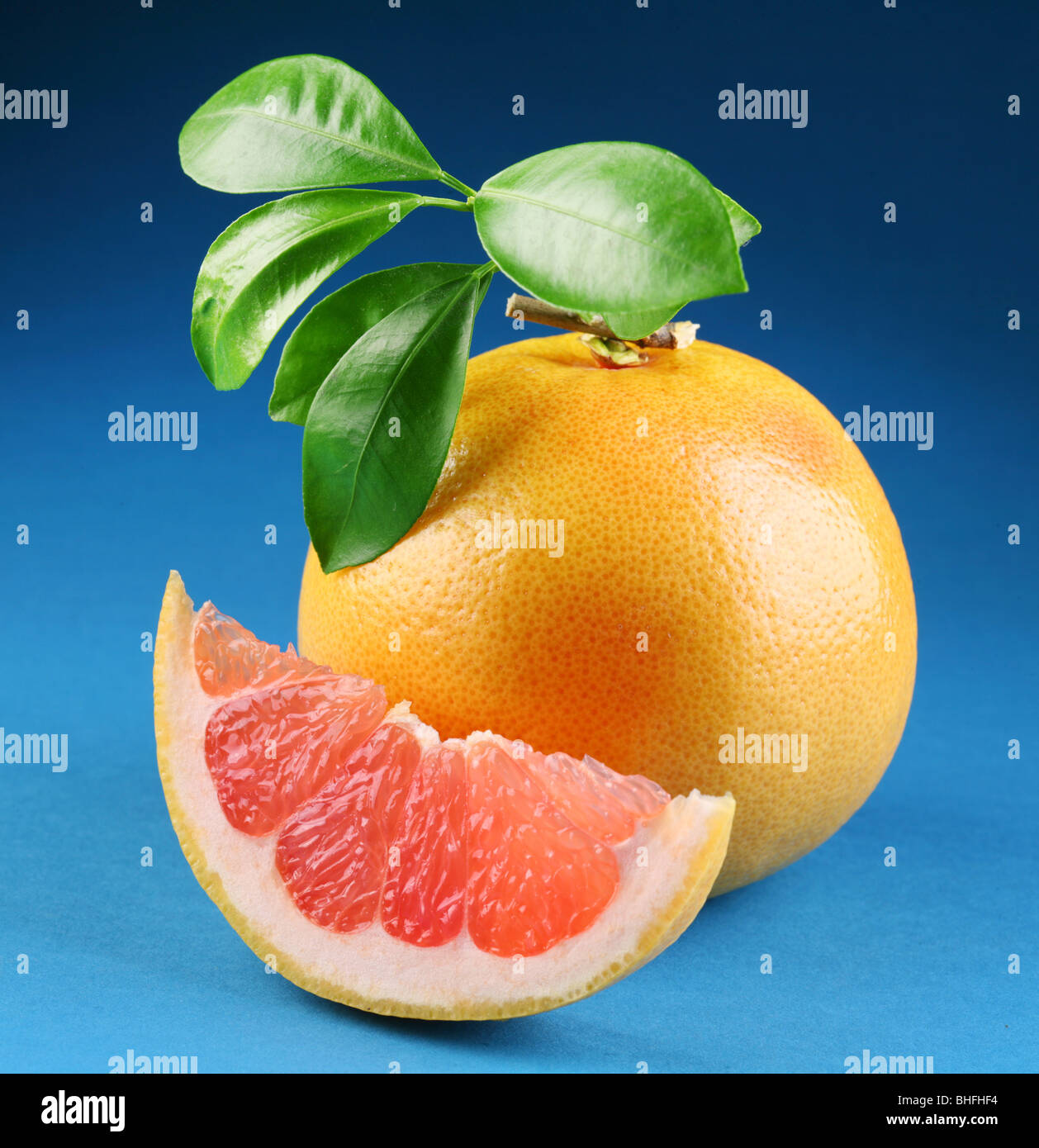 Ripe grapefruit with section on a blue background Stock Photo