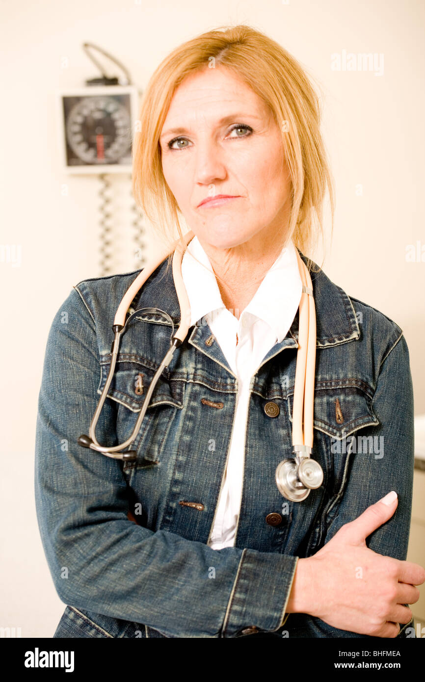 Female doctor wear denim jacket in her exam room in hospital or clinic. Stock Photo