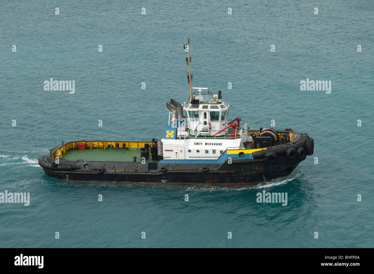 The 'Smit Missouri' tug boat motors across the harbour to provide assistance to another ocean going cargo ship. Stock Photo