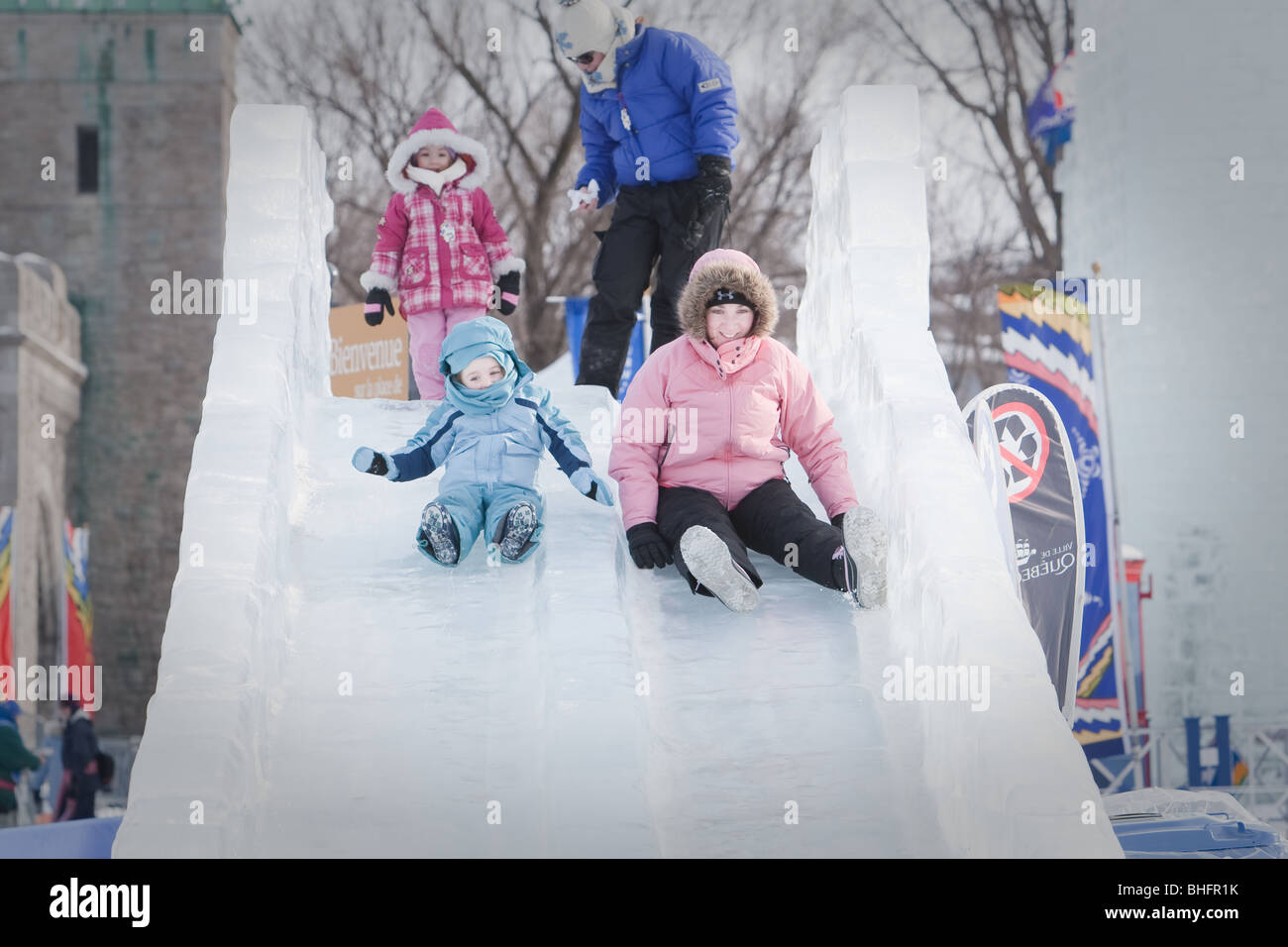 A woman and her daughter ride an ice slide at the Quebec Winter Carnival (Carnaval de Quebec) in Quebec city, Stock Photo