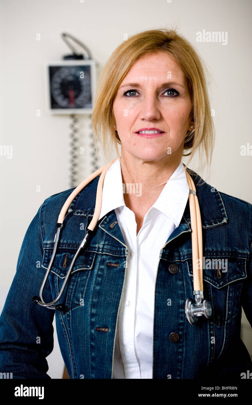 Female doctor wear denim jacket in her exam room in hospital or clinic. Stock Photo