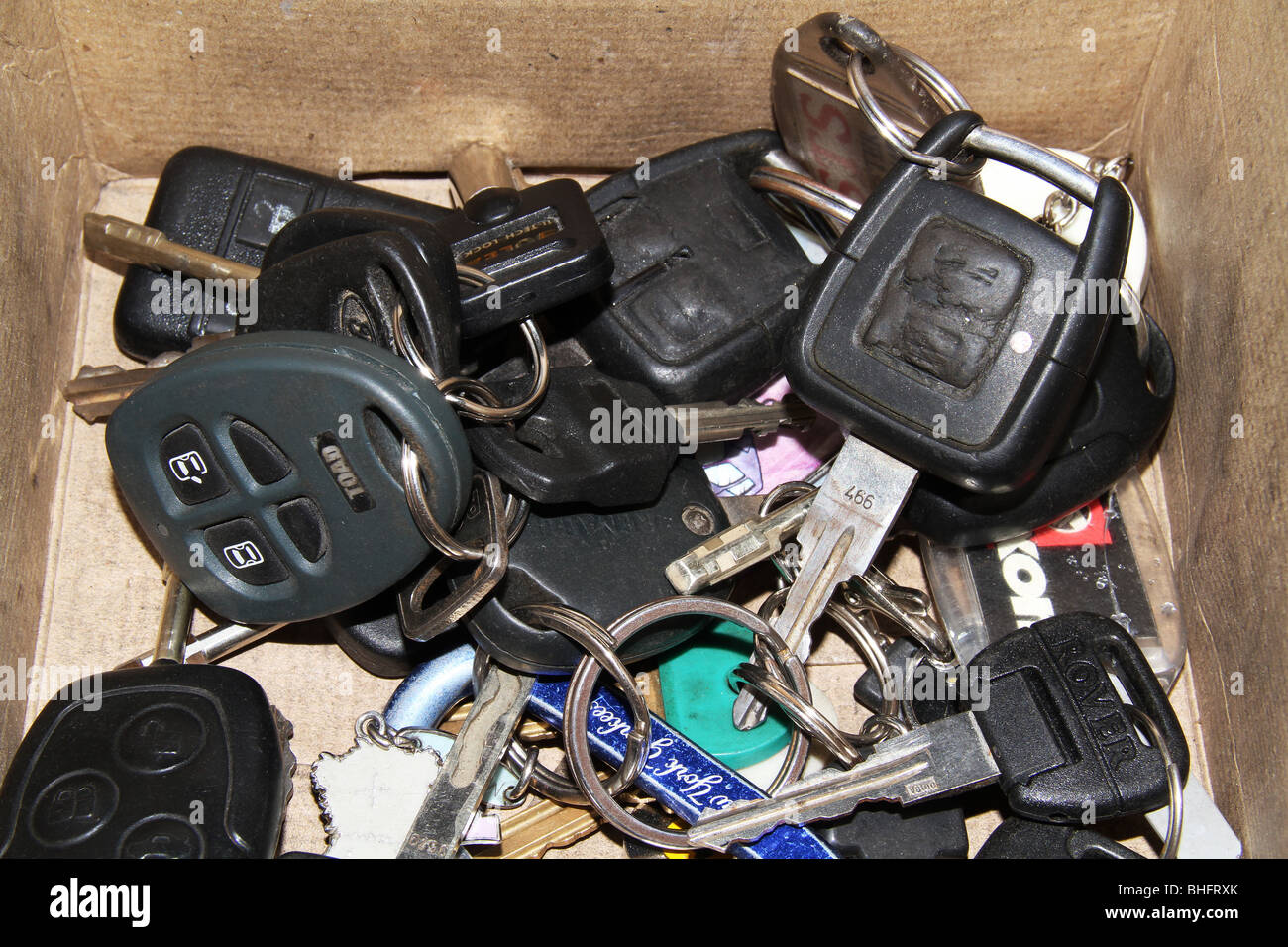 Old vehicle ignition keys of various types in a box. Stock Photo