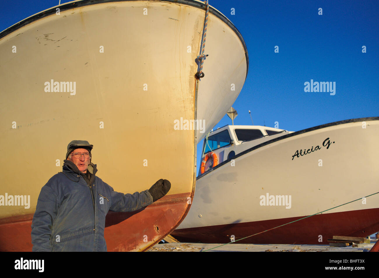 Old fisherman dressed in winter clothes along frozen Miramichi Bay with cap on in New Brunswick Canada Stock Photo