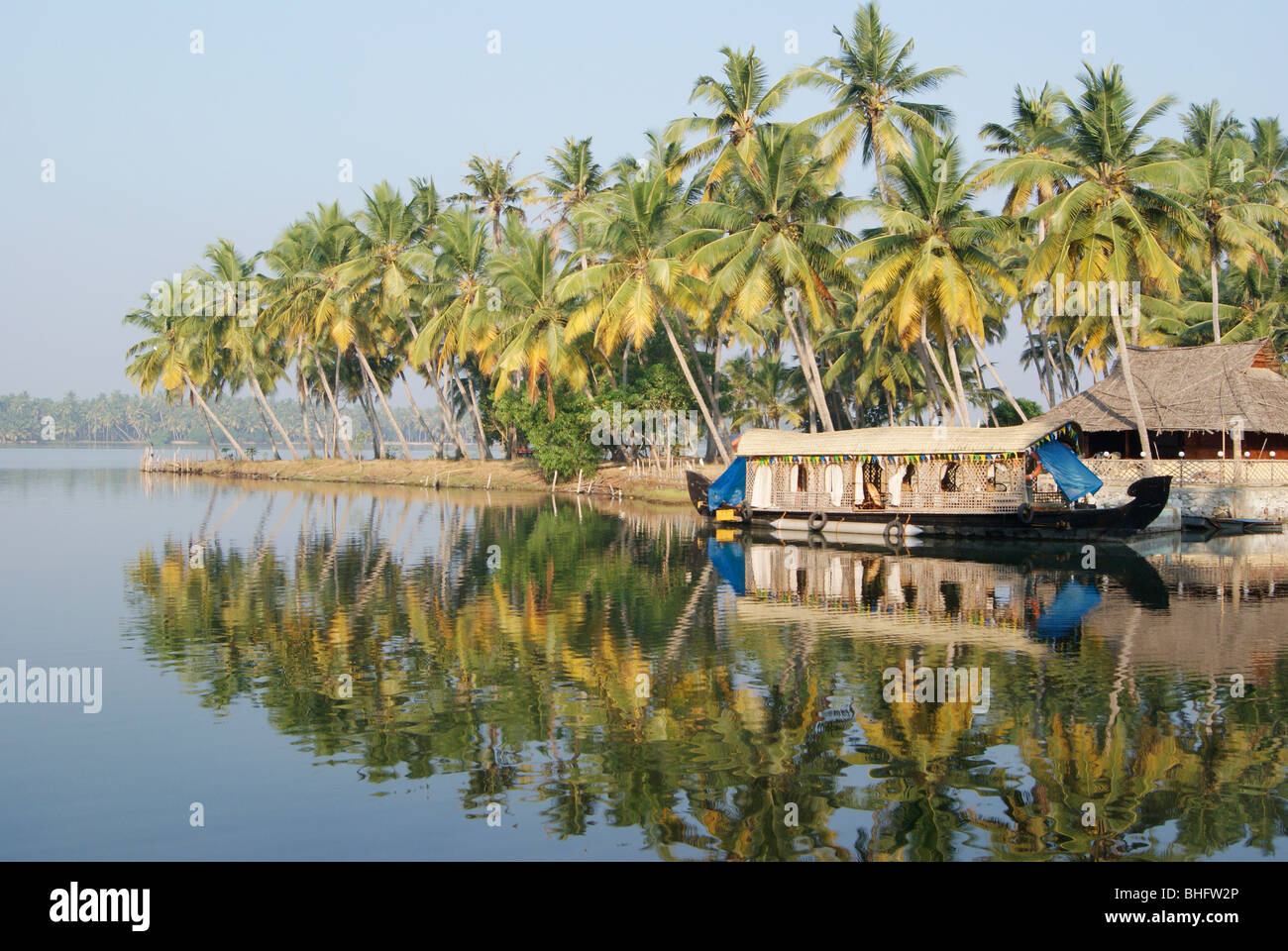 Houseboat Resting on Kerala Backwaters surrounded by coconut Palms at Kerala India Water reflection scenery view Stock Photo
