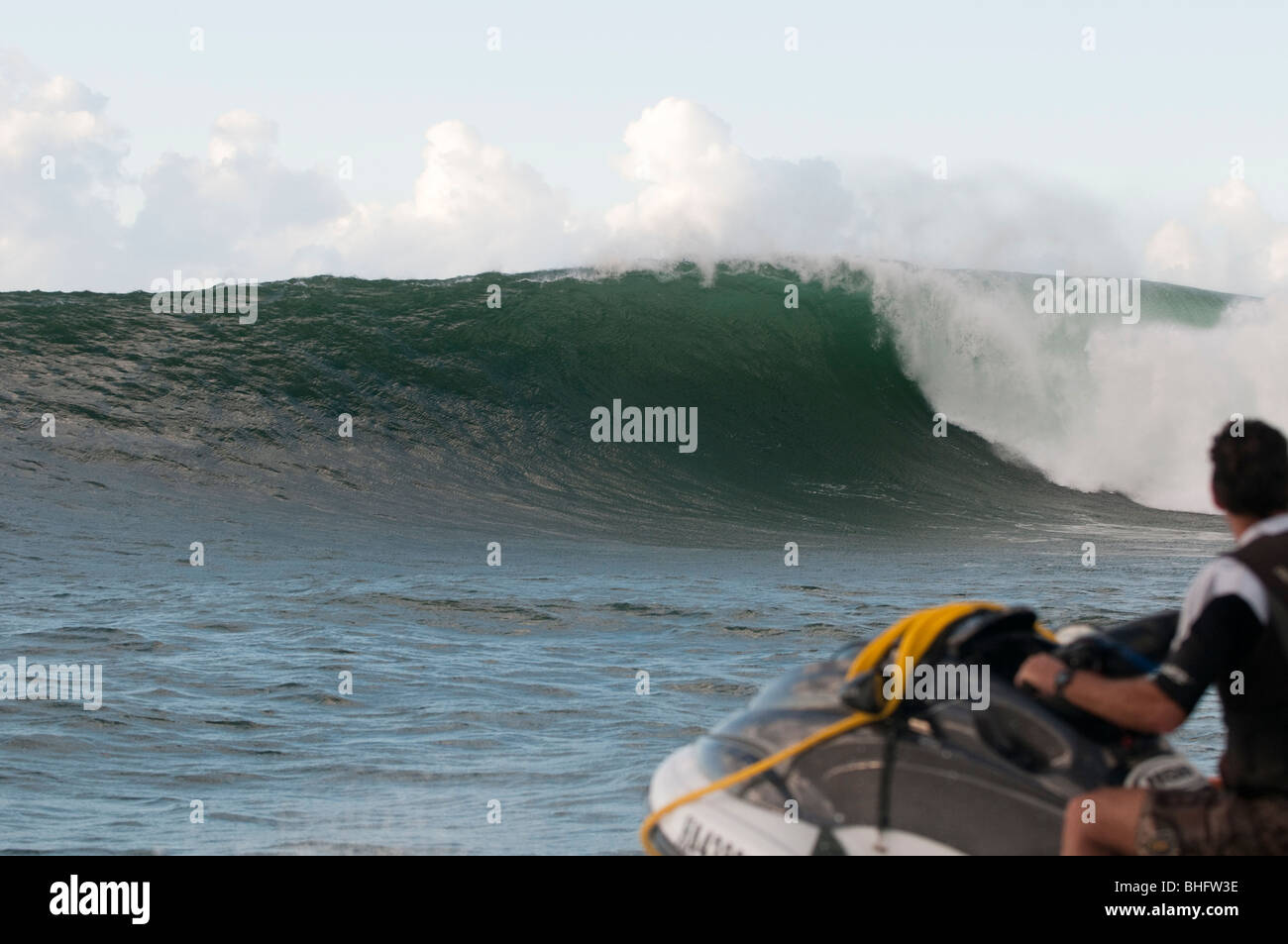 Towin Surfer on jetski watching big wave breaking, Hawaii Stock Photo