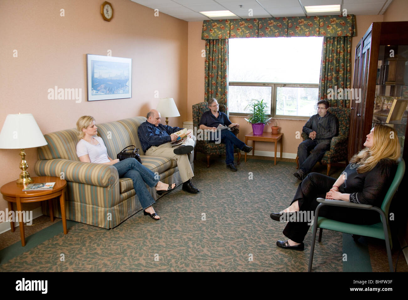 People waiting in holding area or waiting room at a hospital or nursing home. Stock Photo