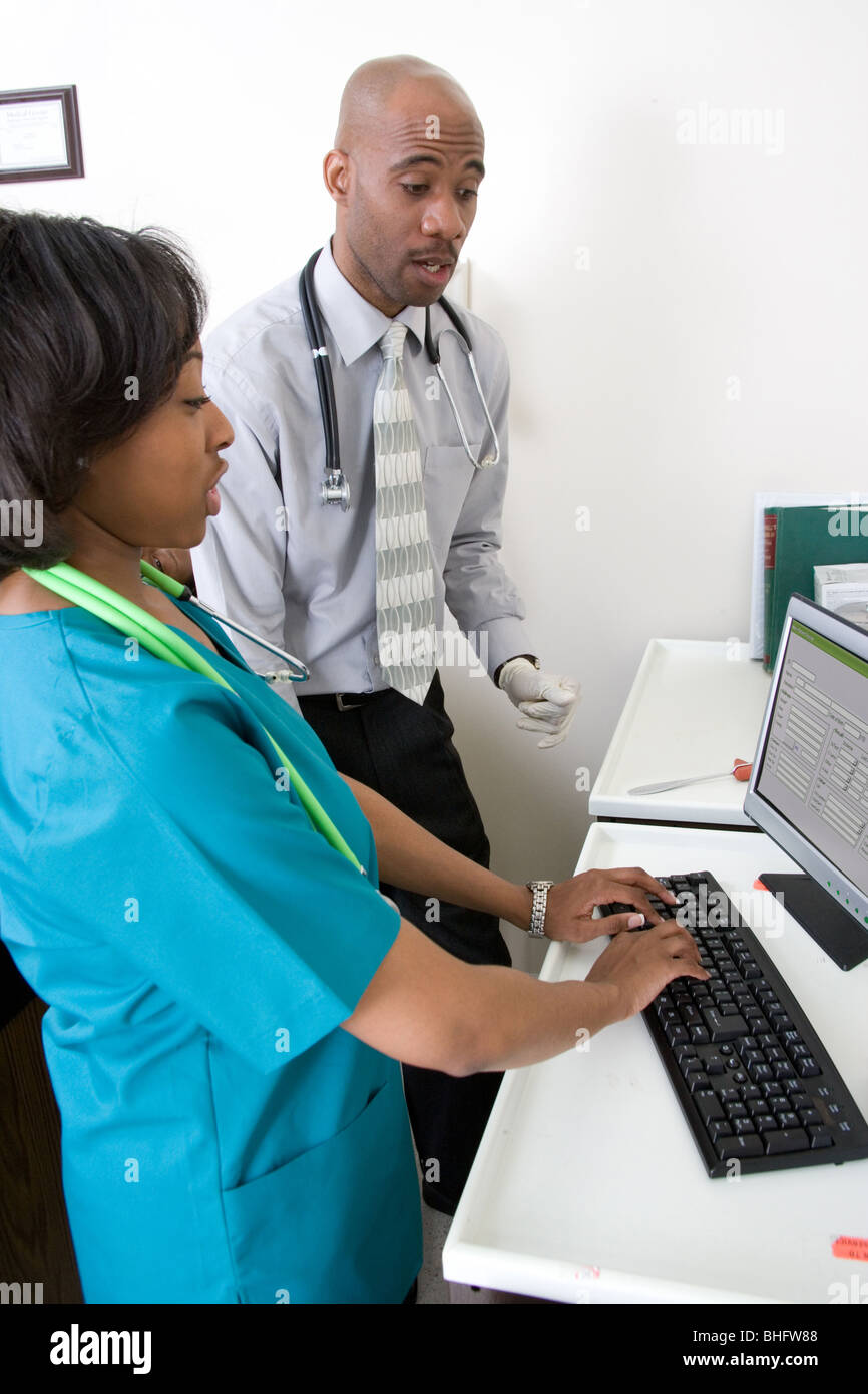 Nurse enters patient data into the hospital or clinic digital record keeping system. 523-1967.jpg Stock Photo