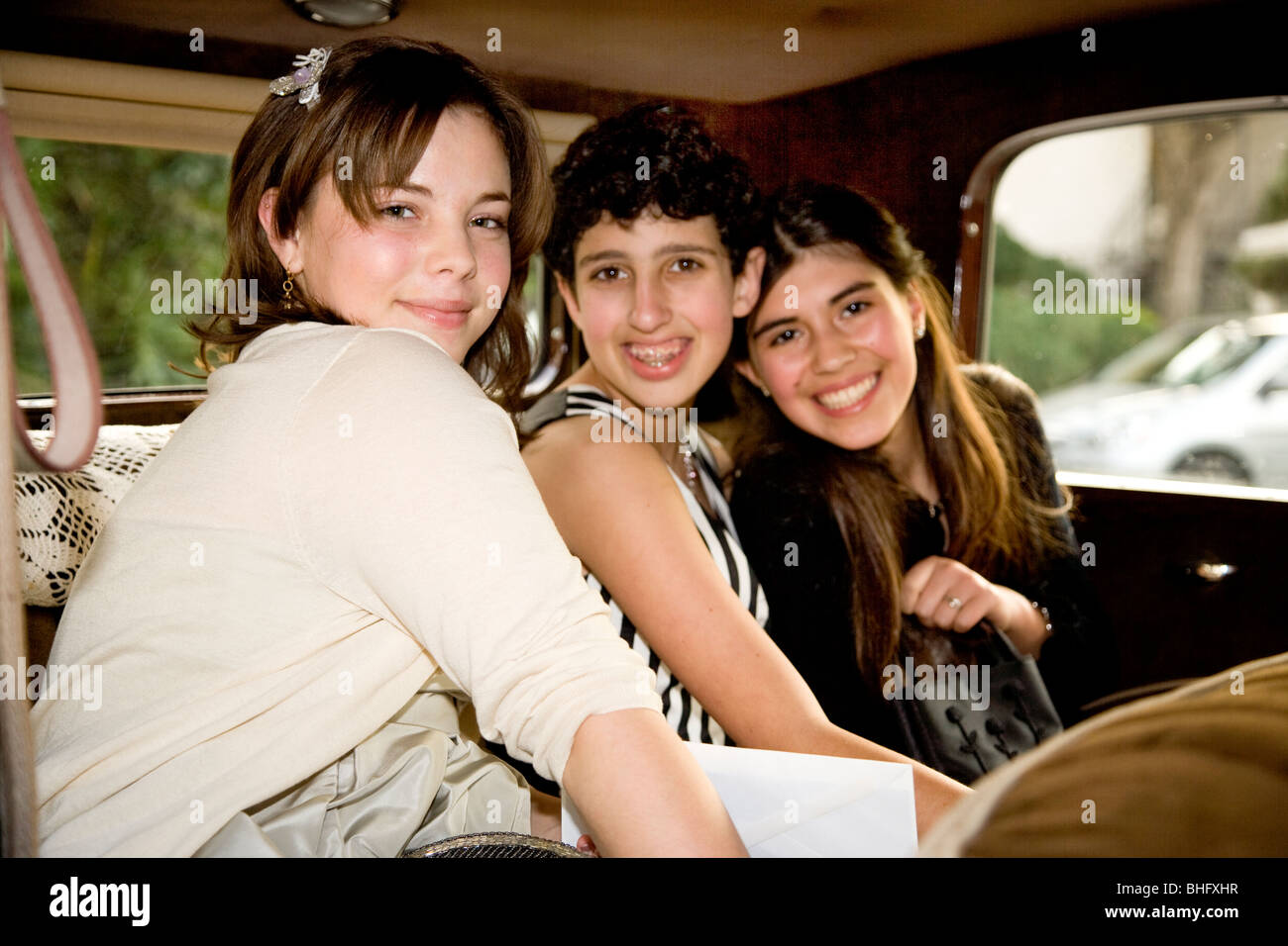 Milti-ethnic middle school girls  in an antique Model A  Ford, as they depart for their Formal Dance at their school. Stock Photo