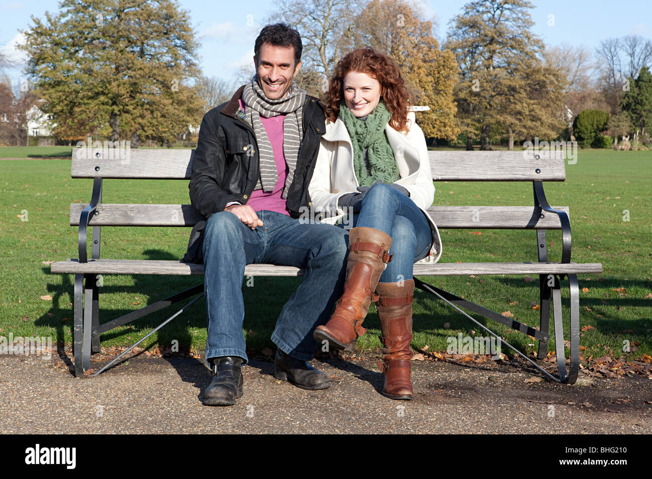 A couple sitting on a park bench Stock Photo - Alamy