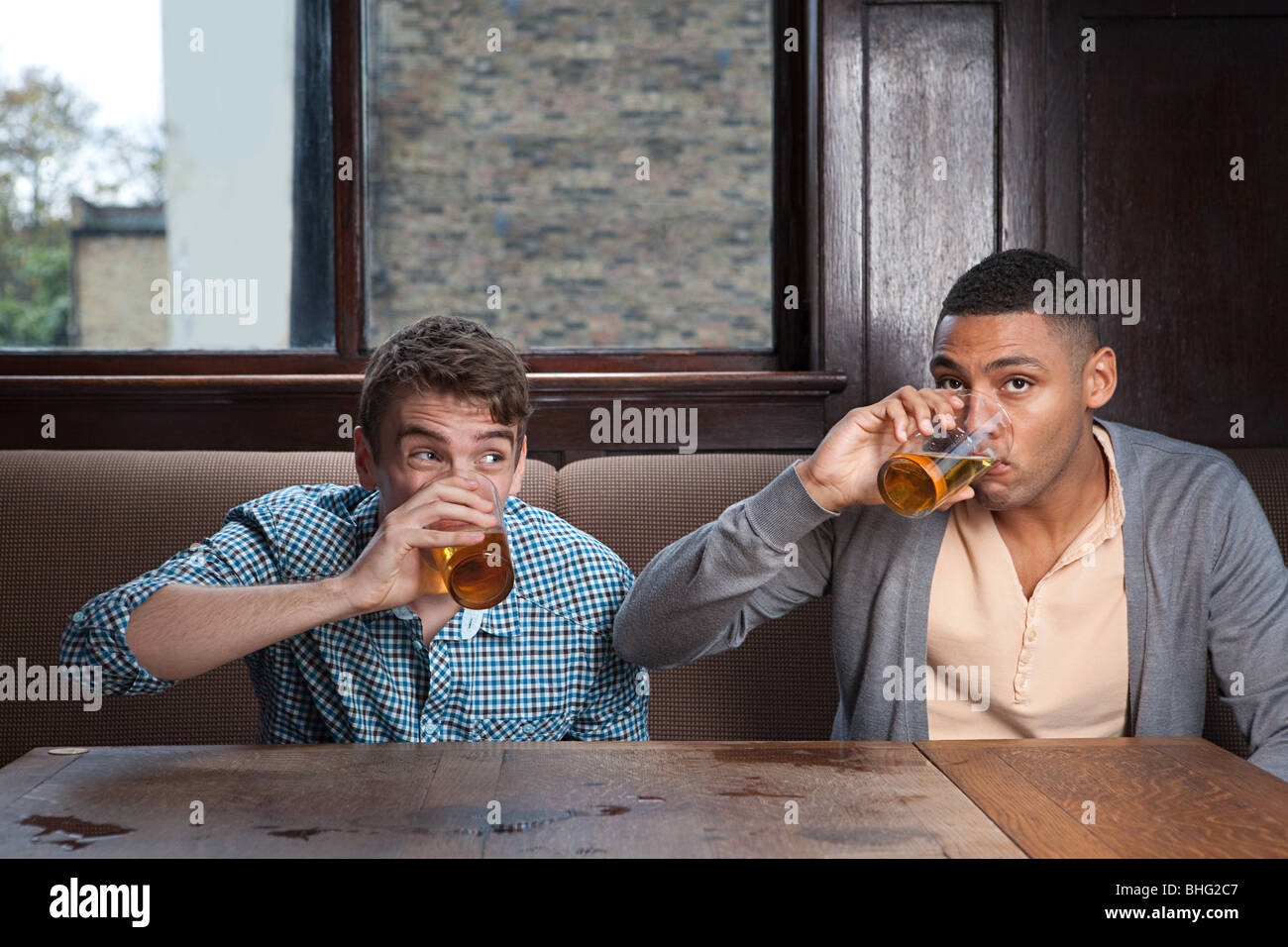 Young men drinking beer in bar Stock Photo