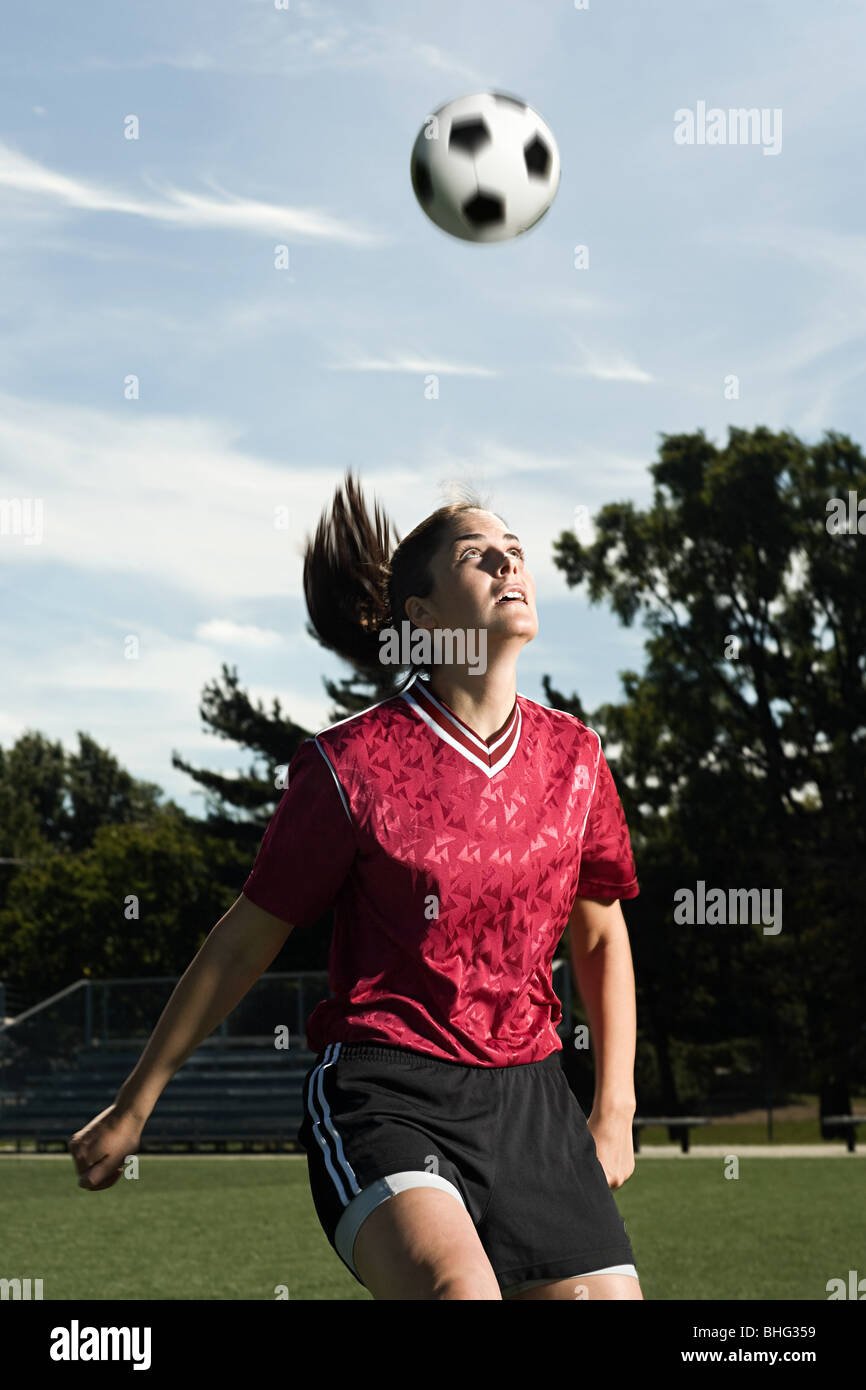 Footballer heading the ball Stock Photo