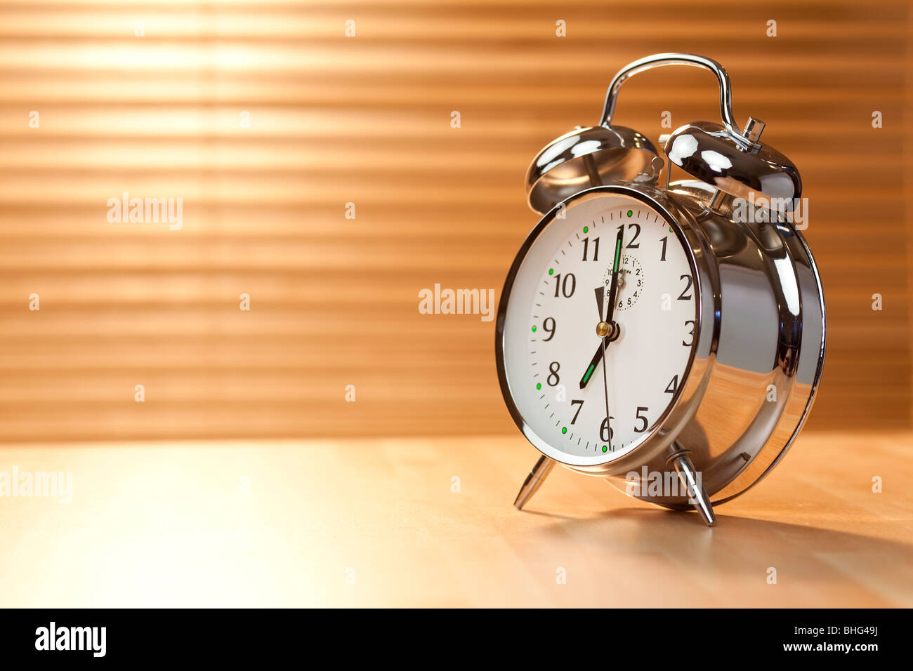 A classic alarm clock illuminated with golden early morning sunshine
