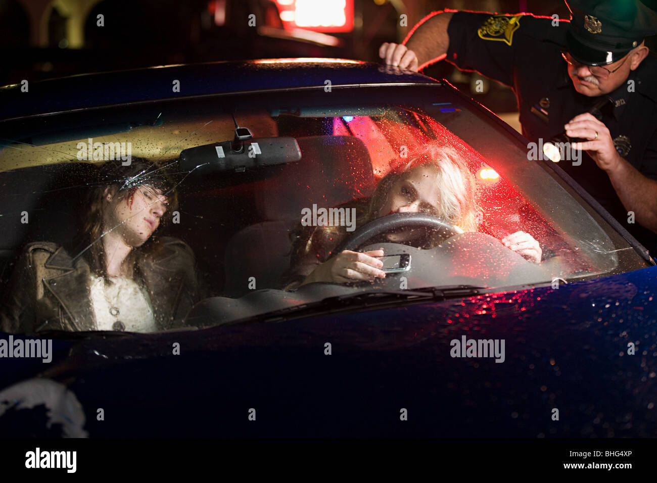 Police officer looking at crashed car Stock Photo - Alamy