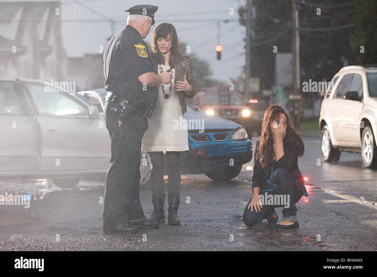 Police officer and young women at scene of accident Stock Photo
