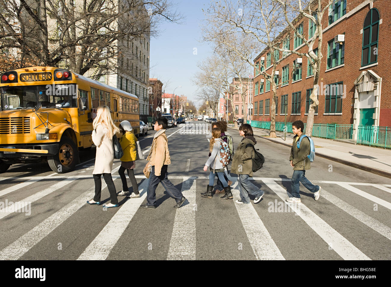 Teacher and pupils crossing road Stock Photo - Alamy