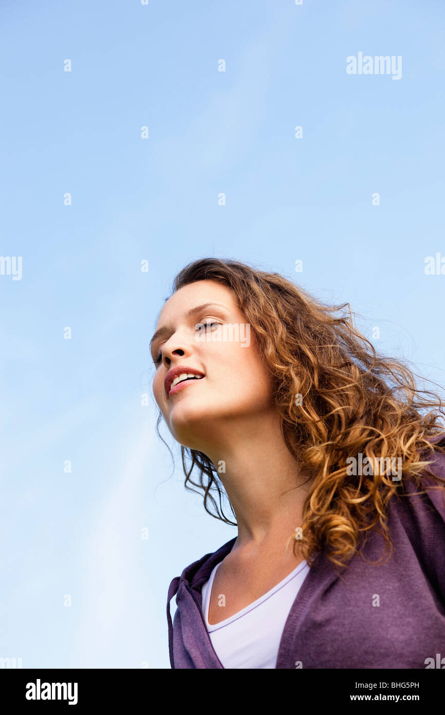 young woman under blue sky Stock Photo - Alamy
