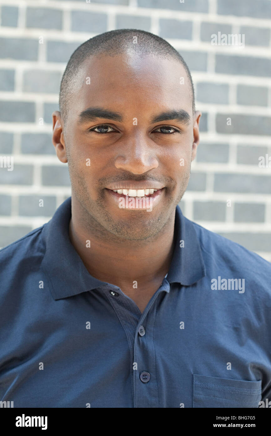 Portrait of young man in front of wall Stock Photo - Alamy