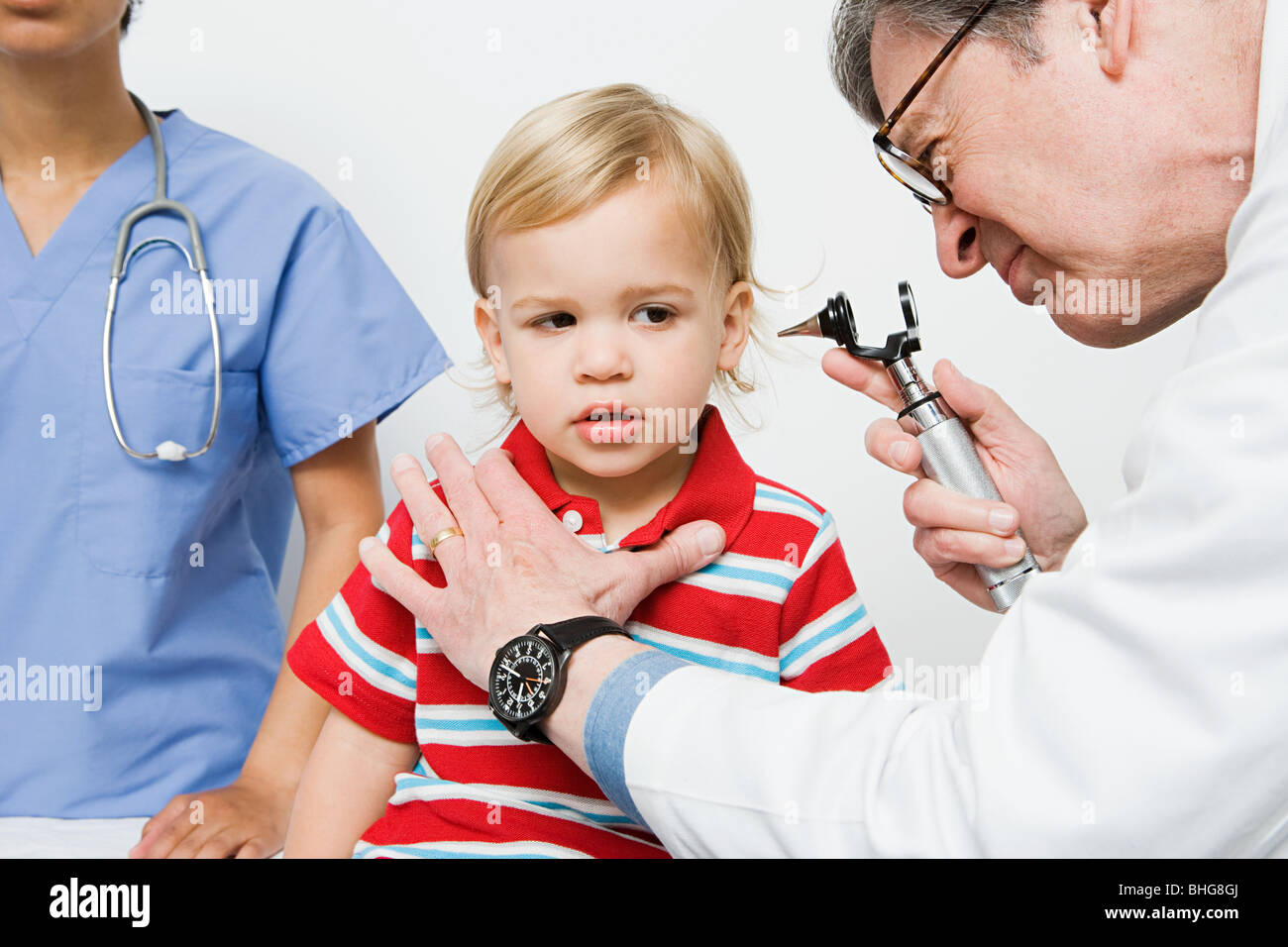 Doctor looking in boys ear Stock Photo - Alamy