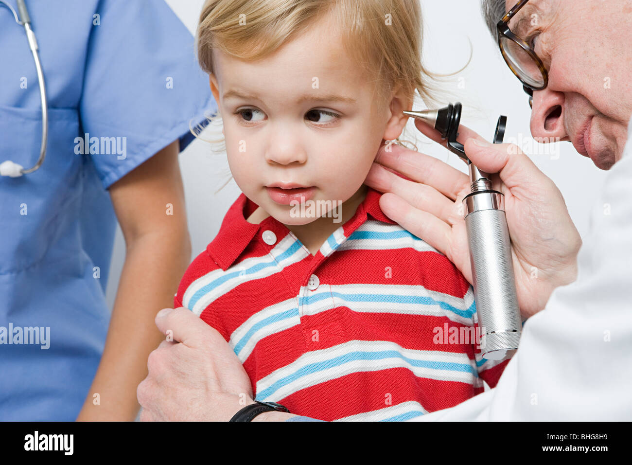 Doctor looking in boys ear Stock Photo - Alamy